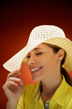 mid adult woman with straw hat smiling and having fun on red background