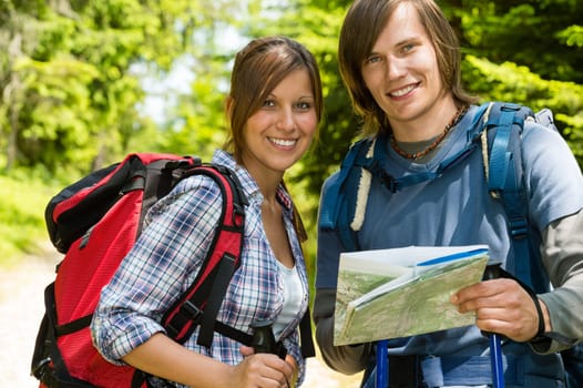 Portrait of smiling trekking couple checking the map