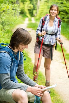 Male hiker watching the map waiting for the girl