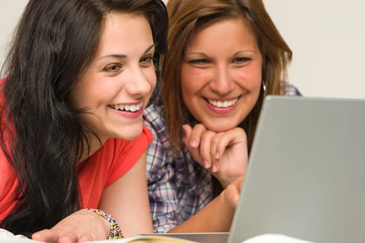 Joyful caucasian teens browsing on internet