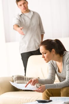 Fighting couple over bills and tax in their living room