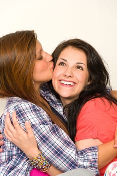 Playful girl gives a kiss to her best friend's face