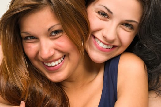 Close up portrait of beautiful girls hugging and smiling