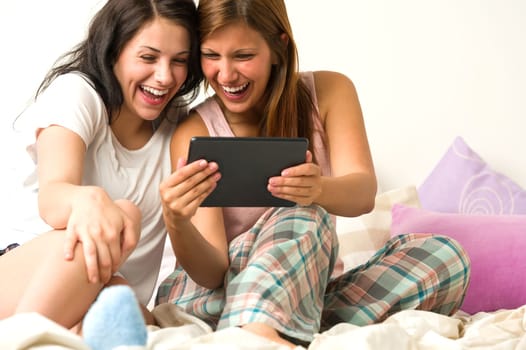 Best friends laughing loudly browsing social network