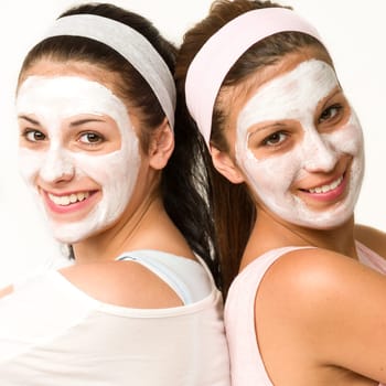 Happy caucasian girls with white facial mask
