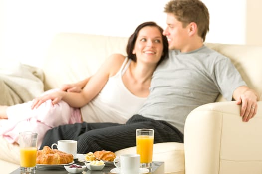 Smiling couple eating breakfast on their honeymoon