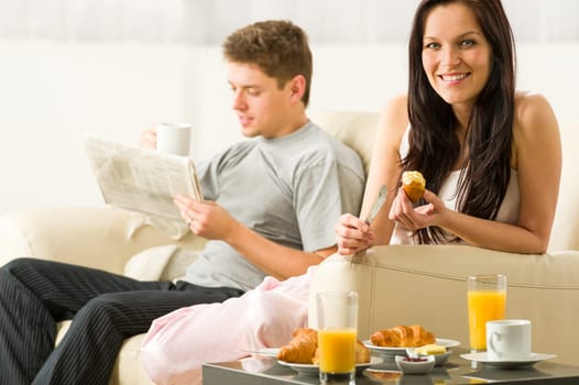 Young couple spending morning time together eating and reading