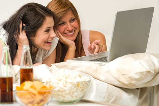 Teenagers friends enjoy movie night watching laptop and laughing