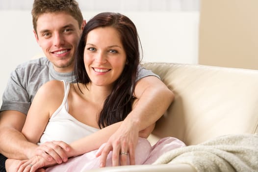 Carefree young couple embracing each other on couch