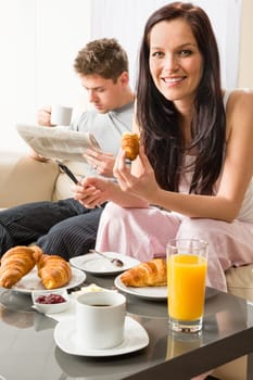 Smiling couple eating romantic breakfast in hotel room