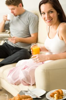 Resting couple having breakfast together in hotel room