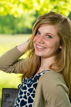 Smiling teenage girl posing outdoors looking at camera
