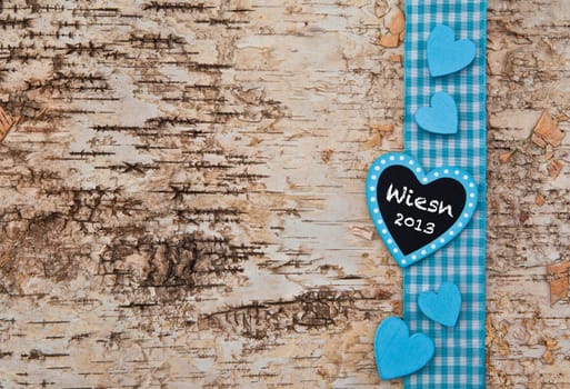 Birch bark background with blue ribbon and hearts