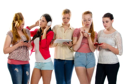 Five girls standing together, each is busy with another activity
