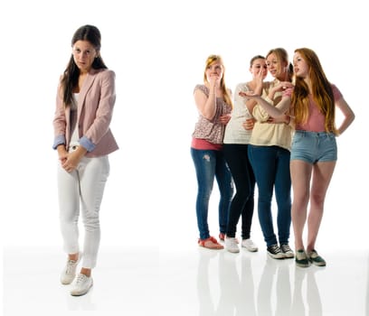 A young girl stands alone on the left edge of the screen, her four girlfriends are in the background and gossip about them.