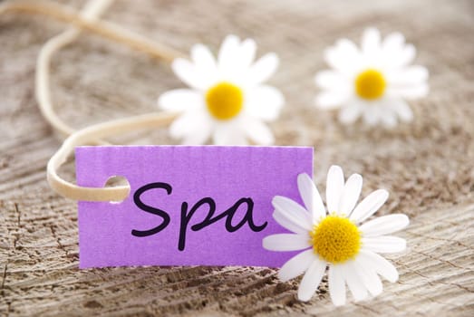 a purple label with the word spa on it and with white blossoms in the background