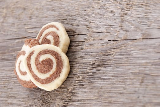 three dark and white cookies lying on a wooden background