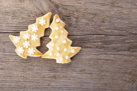 two christmas tree cookies ob a wooden background with copyspace