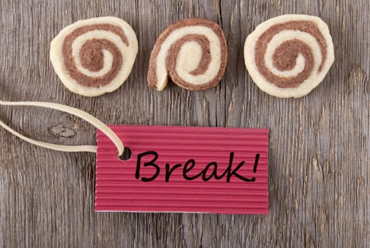 a red label with break on it on a wooden background with three cookies
