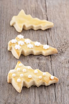 three christmas tree cookies on a wooden background