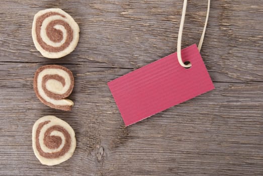 a red sign with copy space and cookies on wood as background
