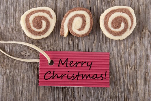 merry christmas written on a red marker tag with some christmas cookies