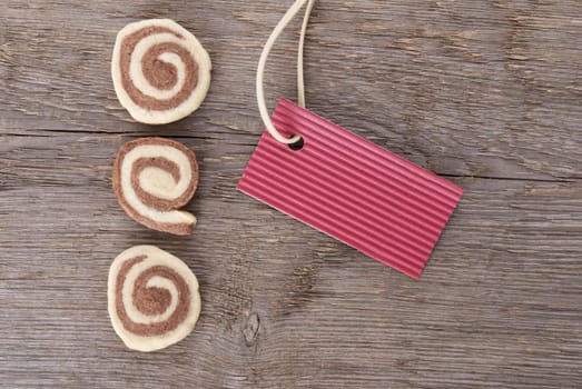 a red sign with copyspace and cookies as background on wood