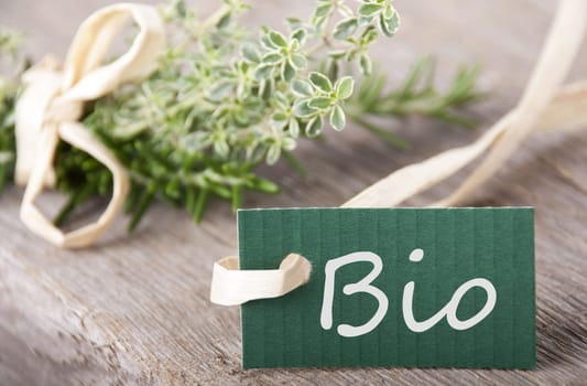 a green label with Bio standing on it with fresh herbs in the background