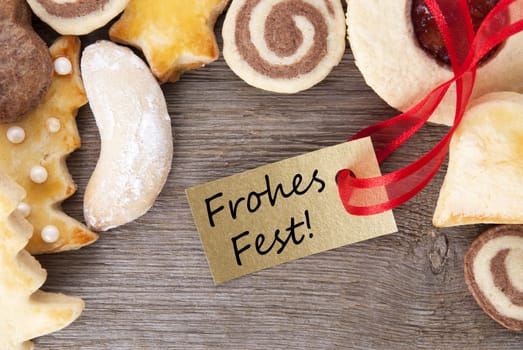 christmas cookie background on wood with golden label with the german words frohes fest which means merry christmas