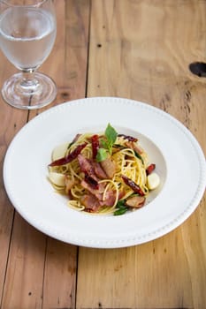 spaghetti with bacon in the pan and herb