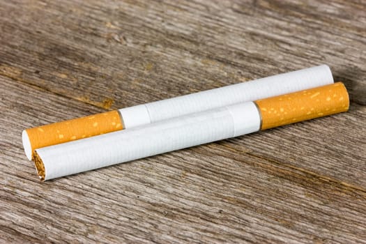 Two cigarettes on the old wooden floor