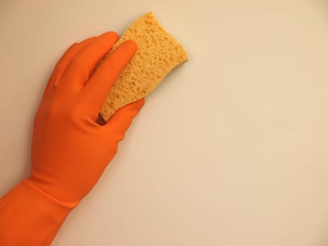 Hand with a rubber glove cleaning a surface