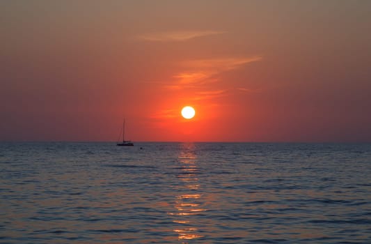 Sunset at sea with a sailboat in Trieste