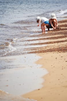 Two little boys playing on the sand beach