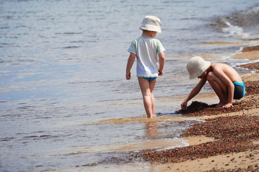 Two little boys playing on the sand beach