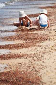 Two little boys playing on the sand beach