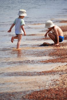 Two little boys playing on the sand beach