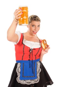 Young attractive woman with blond hair and braids wears a colorful dirdl dress and holds a pretzel and a beer mug with freshly tapped beer in her hand,exposed against a white background.