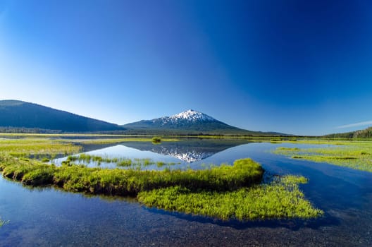 A wide angle view of Mount Bachelor being perfectly reflected in a lake near Bend, Oregon