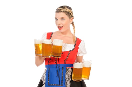 Young attractive woman with blond hair and braids wears a colorful dirdl dress and holds several full beer mugs with freshly tapped beer in her hand,exposed against a white background.