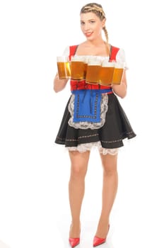Young attractive woman with blond hair and braids wears a colorful dirdl dress and holds several full beer mugs with freshly tapped beer in her hand,exposed against a white background.