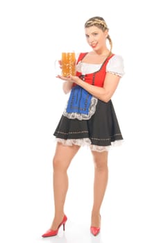 Young attractive woman with blond hair and braids wears a colorful dirdl dress and holds a mug of freshly tapped beer in her hand,exposed against a white background.