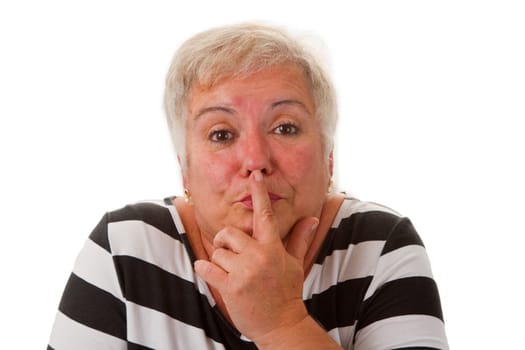 Senior citizen holds index finger in front of her nose - exposed on a white background