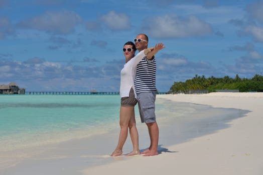 happy young couple have fun and relax at summer vacation on background maldives travel location and beautiful white sand beach