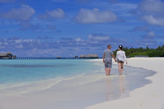 happy young couple have fun and relax at summer vacation on background maldives travel location and beautiful white sand beach
