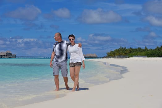 happy young couple have fun and relax at summer vacation on background maldives travel location and beautiful white sand beach