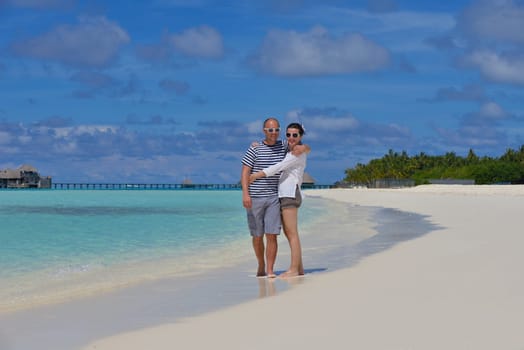 happy young couple have fun and relax at summer vacation on background maldives travel location and beautiful white sand beach