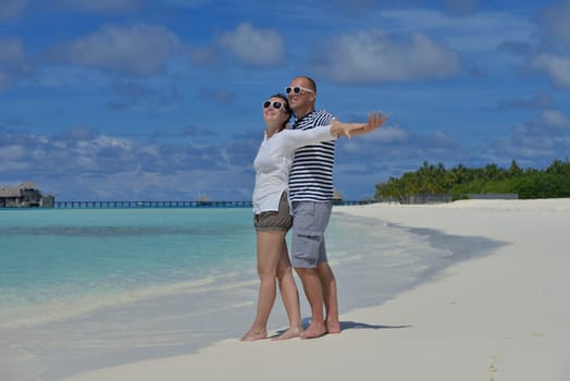 happy young couple have fun and relax at summer vacation on background maldives travel location and beautiful white sand beach
