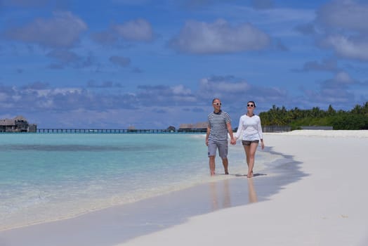 happy young couple have fun and relax at summer vacation on background maldives travel location and beautiful white sand beach