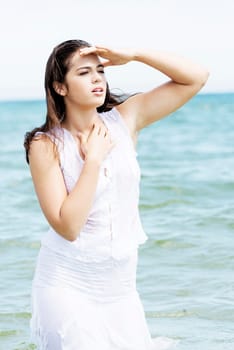 summer woman on the beach looking far away.